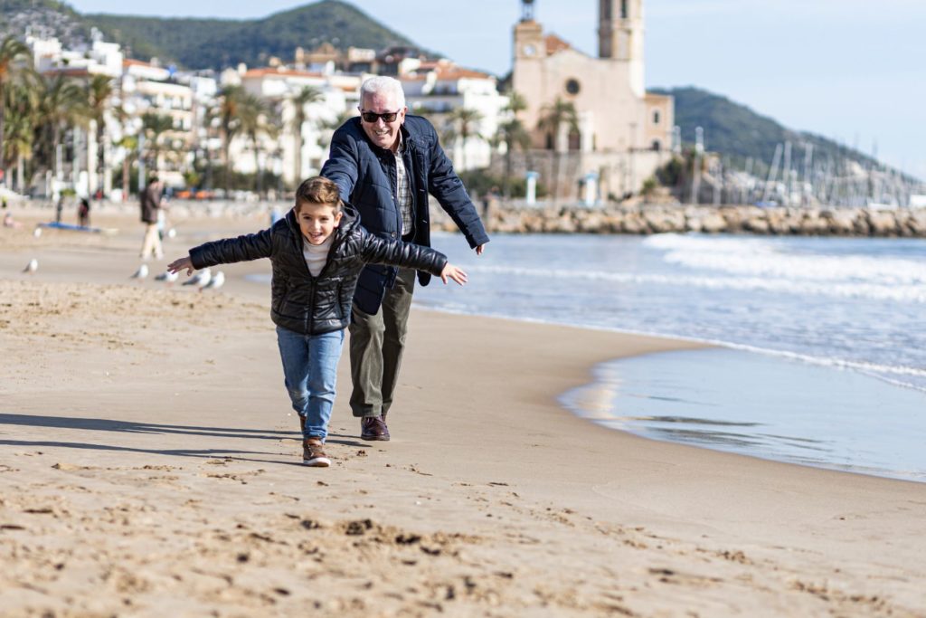 Grandfather playing with grandson in Sitges, Spain