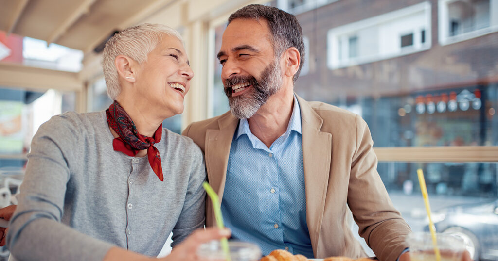 Mature couple laughing in a coffee shop in Italy.