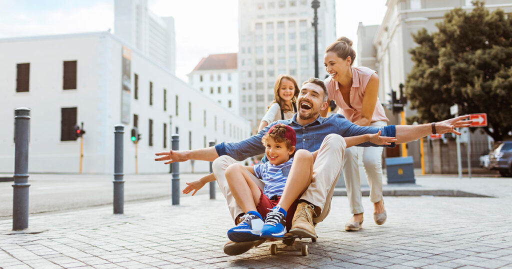 mother and father playing outside with young children