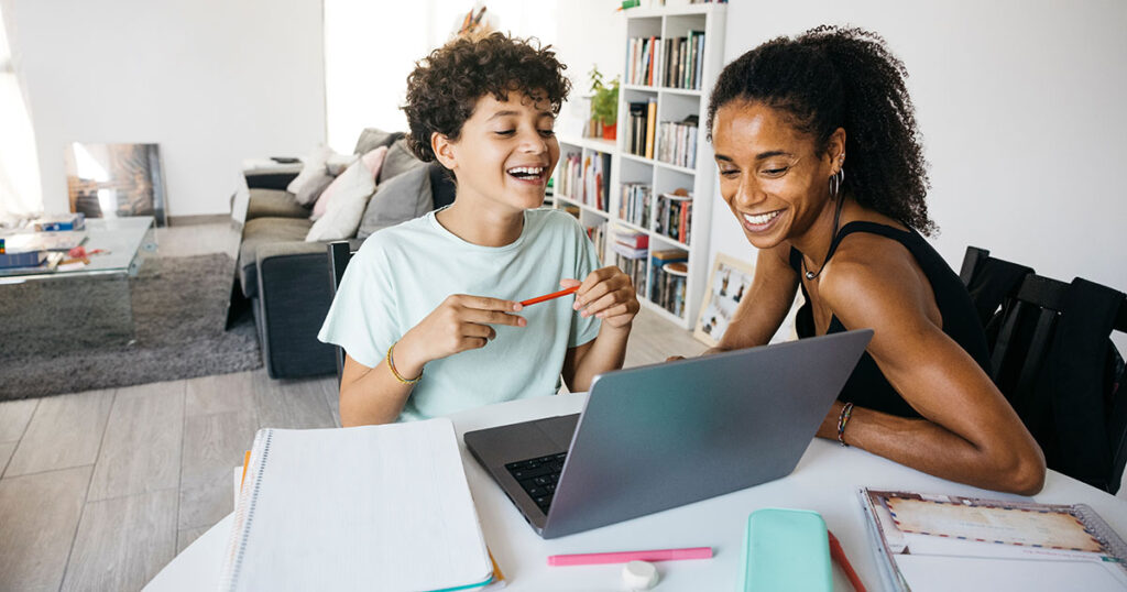 Young mom sitting with child working on homework.