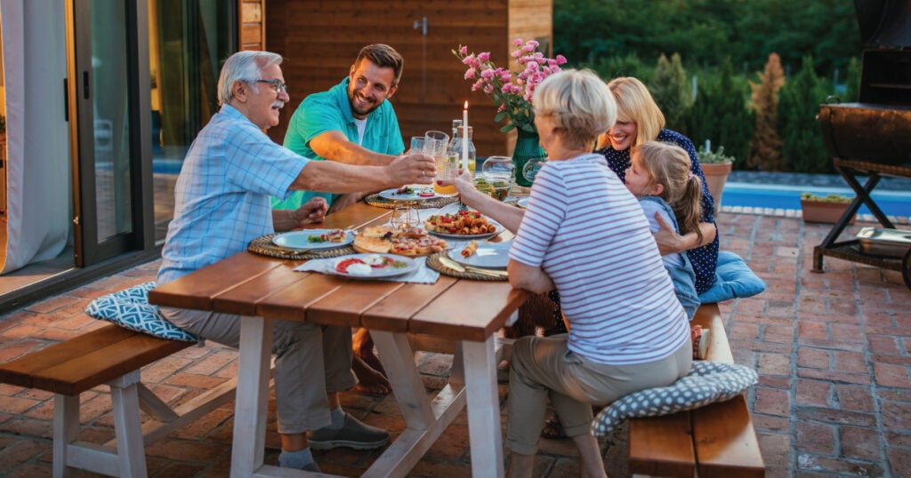 Family dining outside with adult children and grandparents
