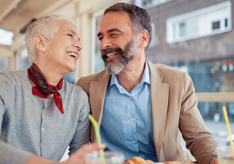 Mature couple laughing in a coffee shop in Italy.