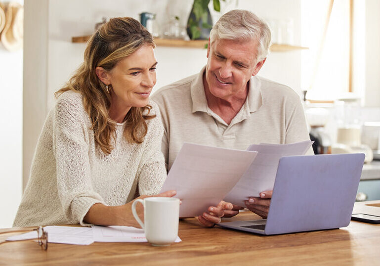 Couple looking at documents together on kitchen counter.
