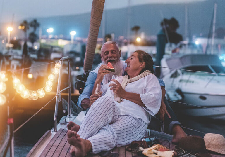 Couple relaxing on boat at harbor during dusk