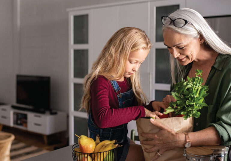 Woman with granddaughter with groceries