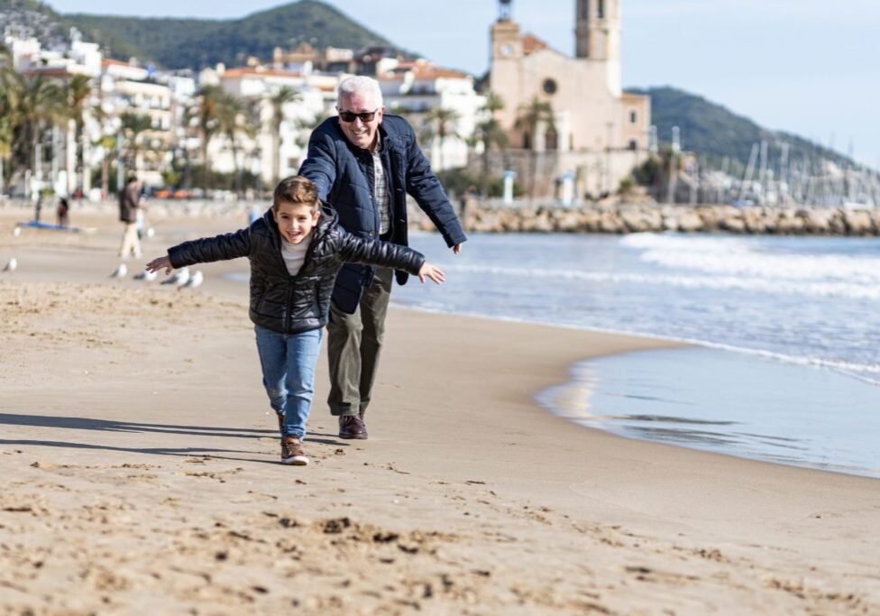 Grandfather playing with grandson in Sitges, Spain