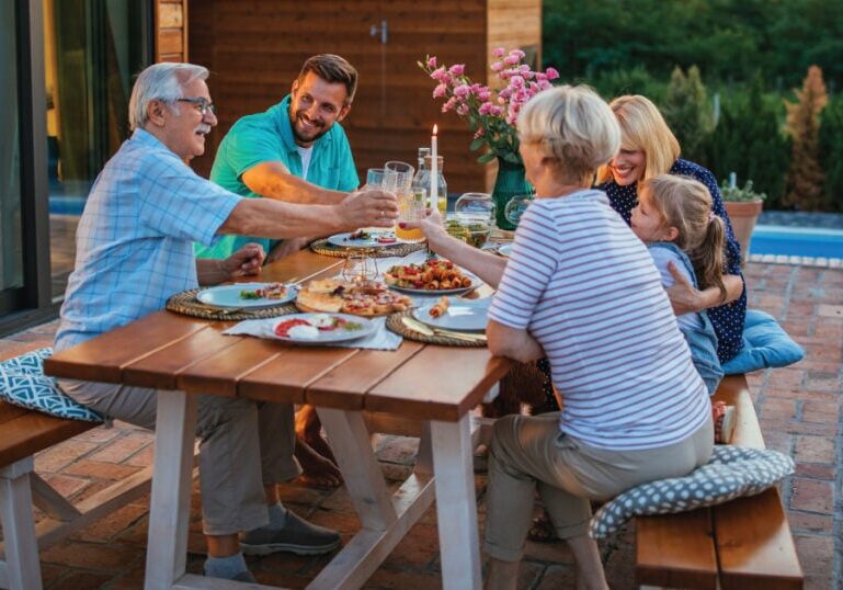 Family dining outside with adult children and grandparents