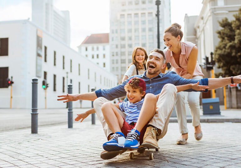 mother and father playing outside with young children