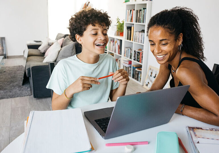 Young mom sitting with child working on homework.