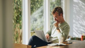 Man sitting at kitchen table on laptop