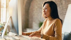 A woman is working on her laptop