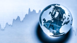 Image of an etched glass globe paperweight in front of what looks like a financial chart