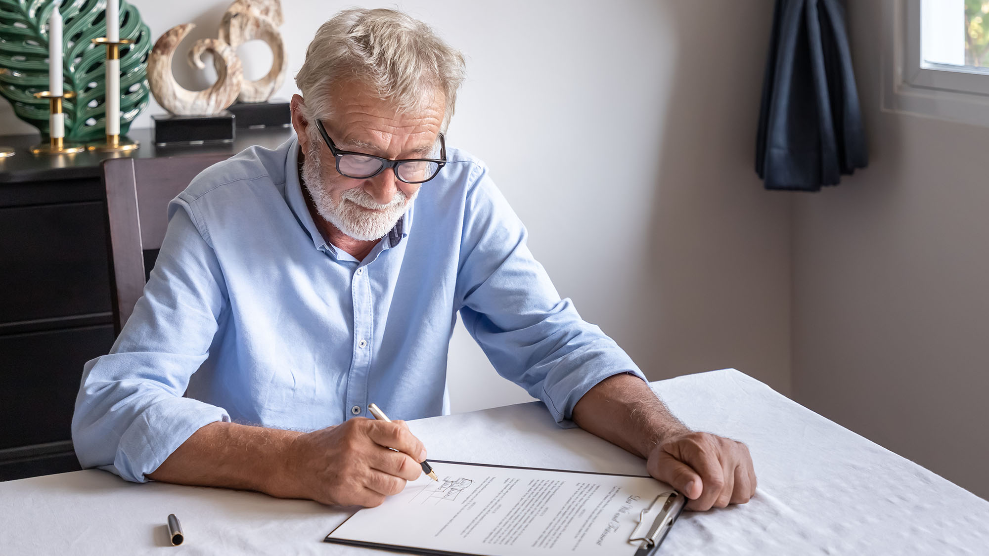 Senior man examining and signing his will