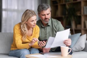 Married Middle Aged Couple Planning Budget Together, Reading Papers