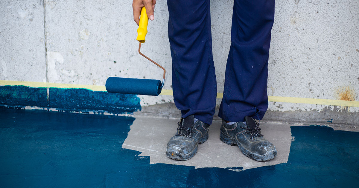 Man painting around his feet with blue paint