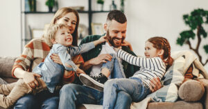 Happy couple sitting on a couch with kids.