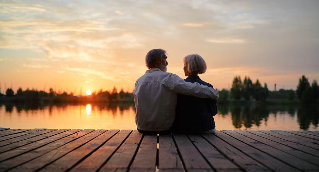 Senior couple overlooks water while discussing end-of-life planning