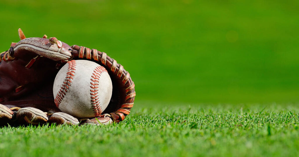 baseball glove and ball in the grass