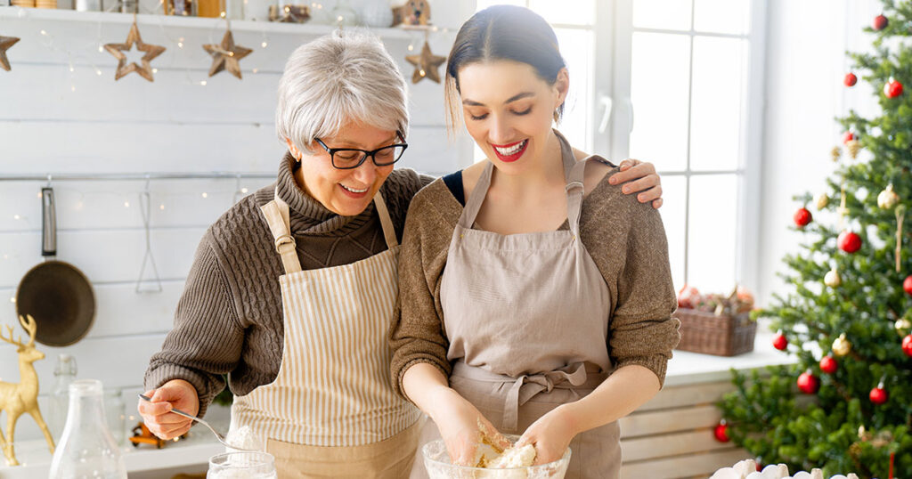 Woman and adult daughter bake cookies during the holidays