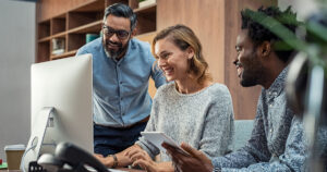 Business team reviewing data on computer and tablet