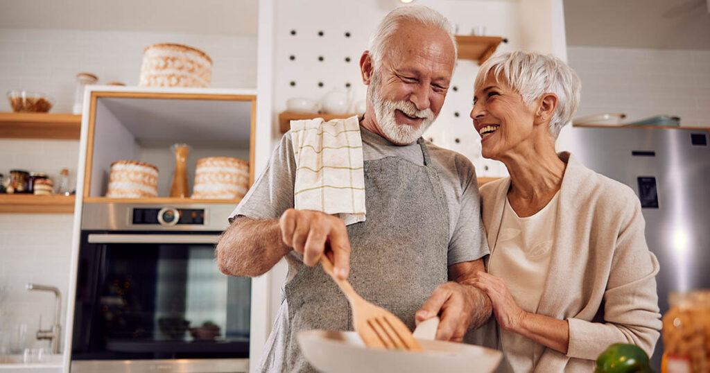 woman and husband cook together while discussing changes coming to Medicare in 2025