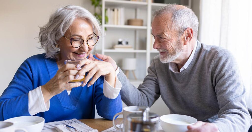 Senior couple sitting at a dining table discussing investment strategies like direct indexing and wealth planning.