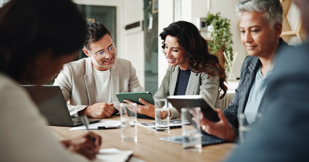 Multi-generational family office team reviewing tax and investment documents together at a conference table
