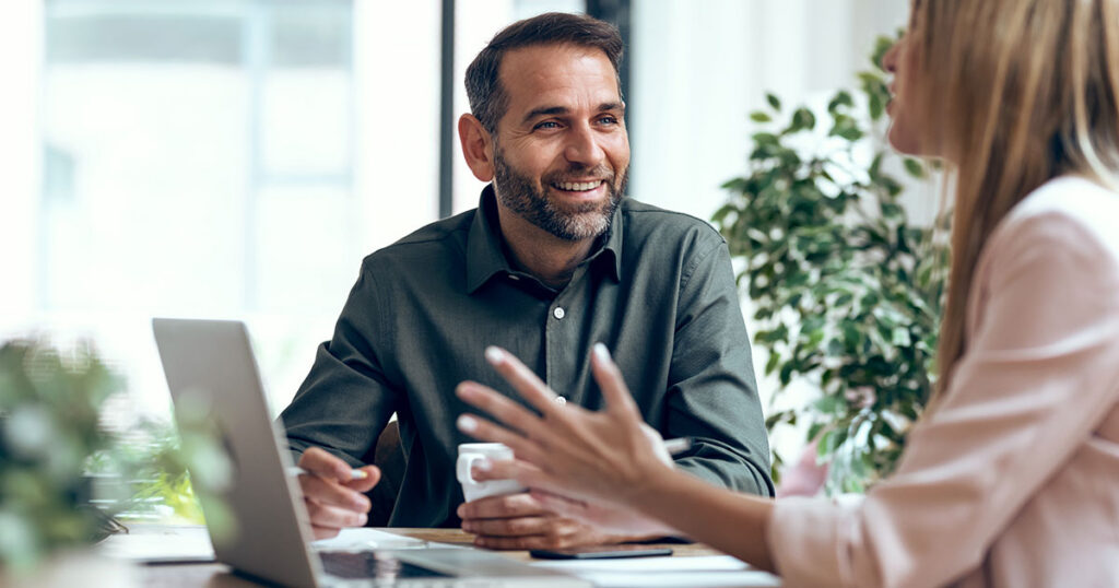 Business leader discussing artificial intelligence strategy with colleague during meeting about AI disillusionment
