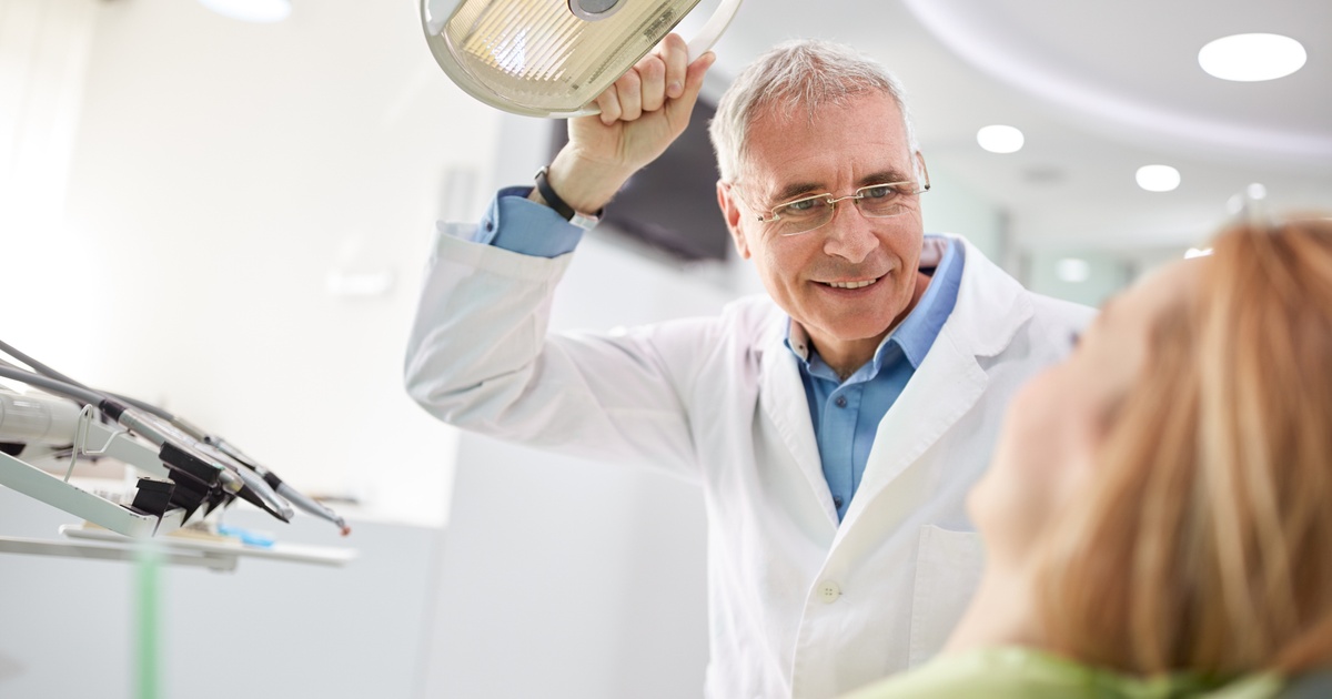 Dentist speaking with a patient during a visit at a dental office image