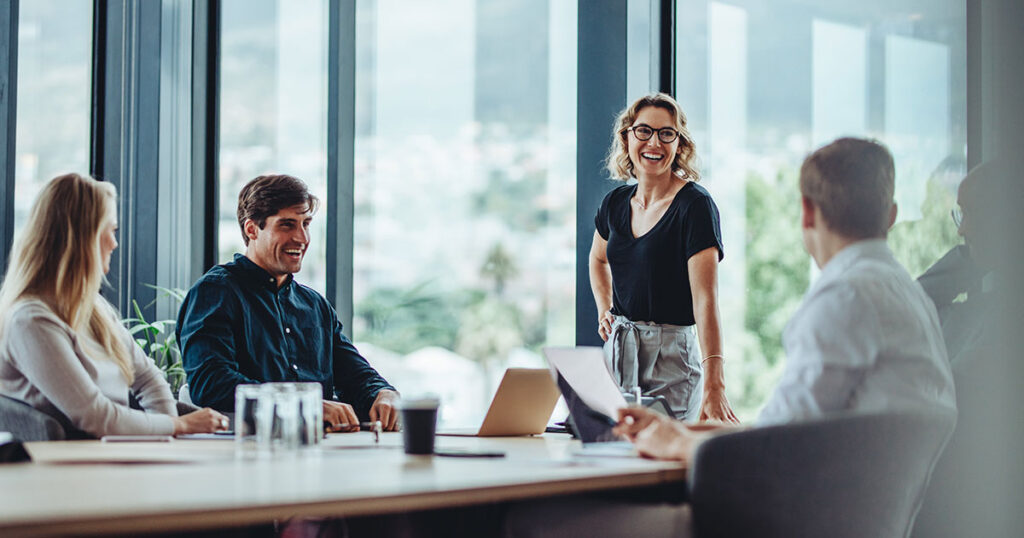 Group of professionals meeting around a conference table in a modern glass-walled boardroom, representing family office governance models and structured decision-making for multigenerational wealth