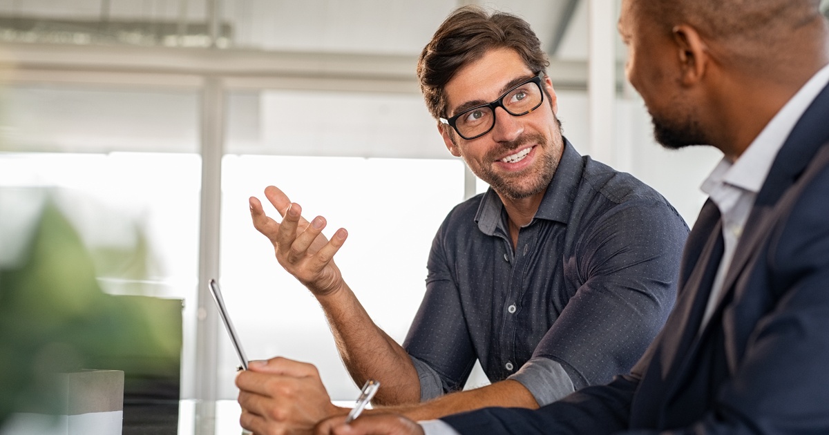 Two professionals having a discussion during a business meeting.