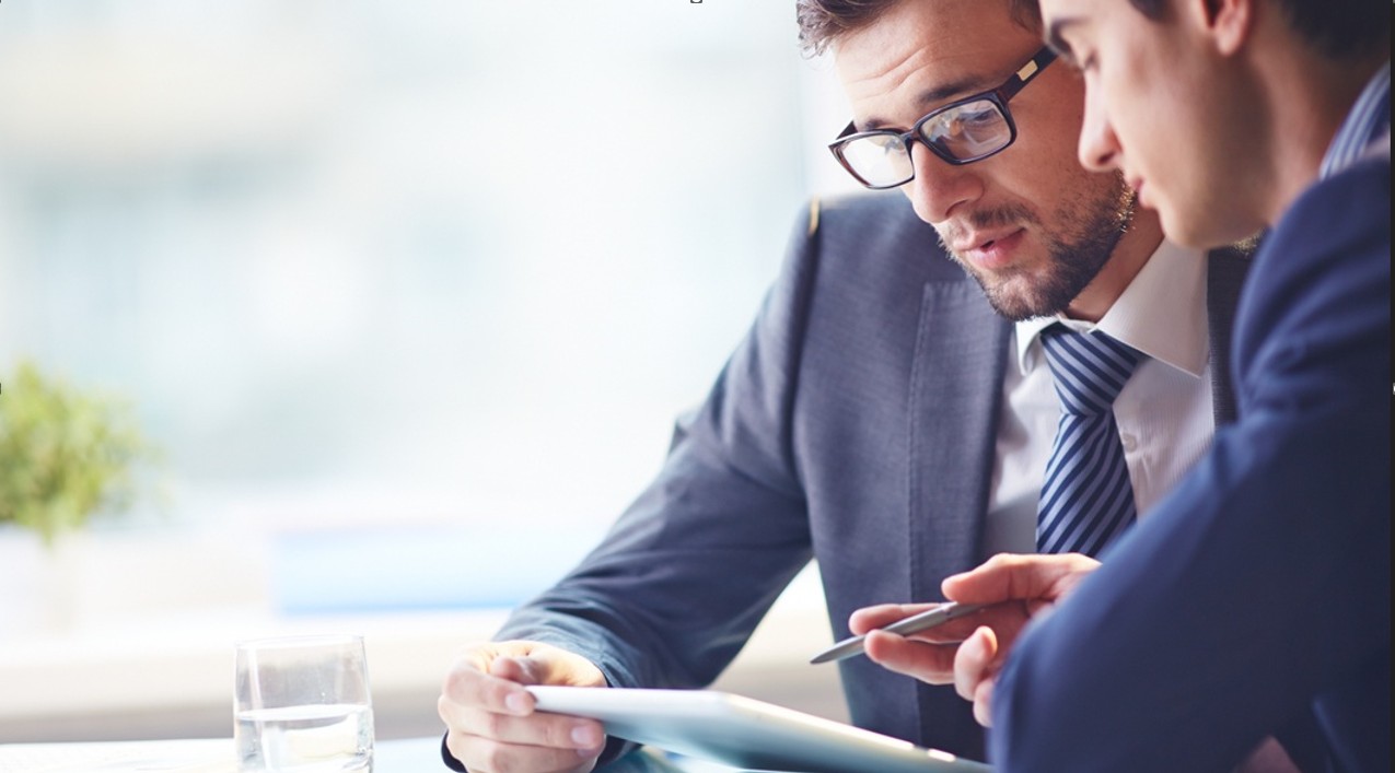 Two business professionals reviewing a document together during a meeting.
