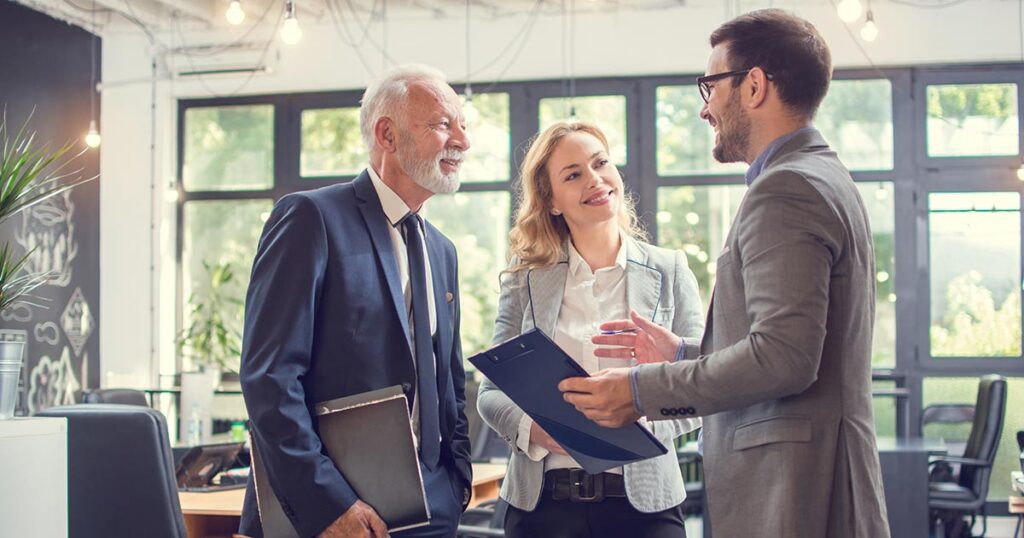 Financial advisors discussing family office wealth management and governance strategies with clients in a modern office setting.