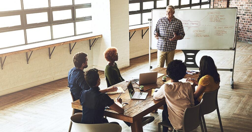 Nonprofit board and leadership team meeting around a conference table discussing governance, financial reporting, and Form 990 transparency initiatives.