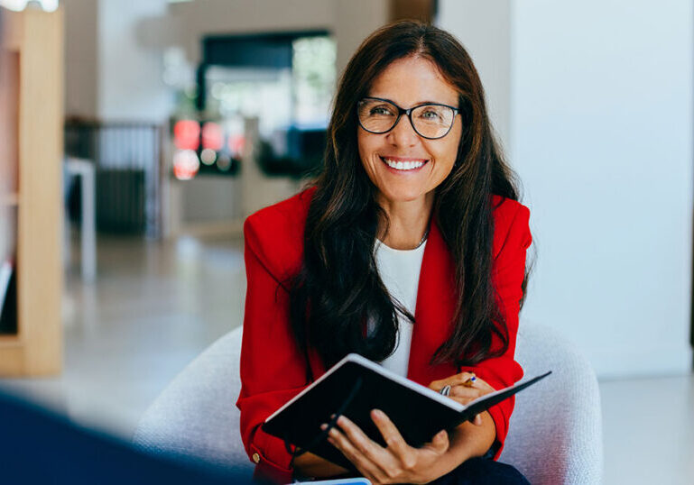 Female advisor in red blazer meeting with client to discuss family office wealth management strategy