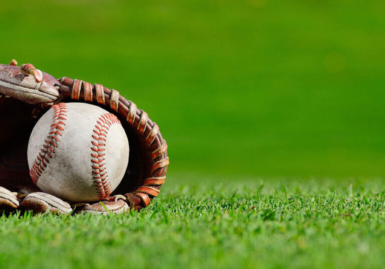 baseball glove and ball in the grass