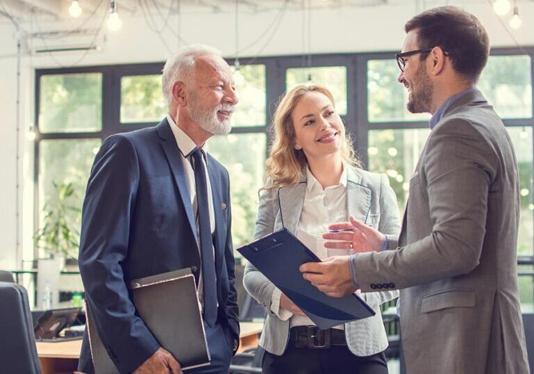 Financial advisors discussing family office wealth management and governance strategies with clients in a modern office setting.