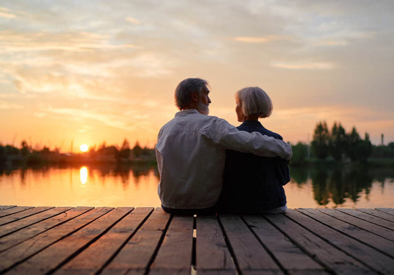 Senior couple overlooks water while discussing end-of-life planning