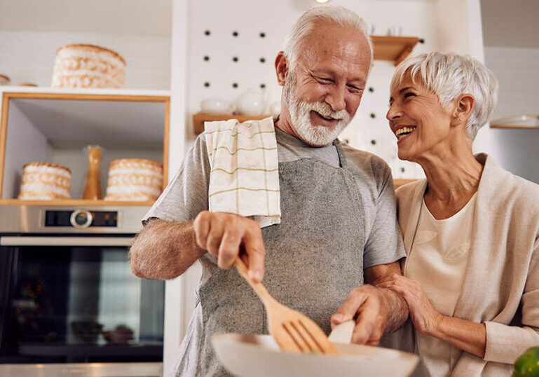 woman and husband cook together while discussing changes coming to Medicare in 2025