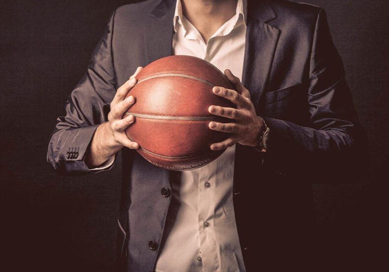 retired athlete in suit seeking a second career holds a basketball