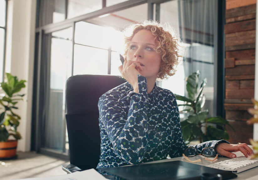 Woman sitting at desk contemplating future