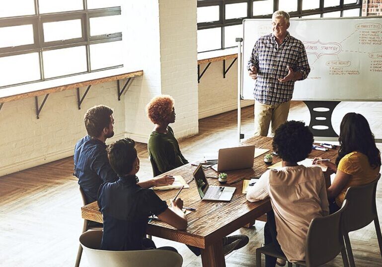 Nonprofit board and leadership team meeting around a conference table discussing governance, financial reporting, and Form 990 transparency initiatives.
