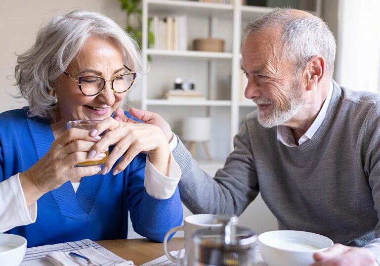 Senior couple sitting at a dining table discussing investment strategies like direct indexing and wealth planning.